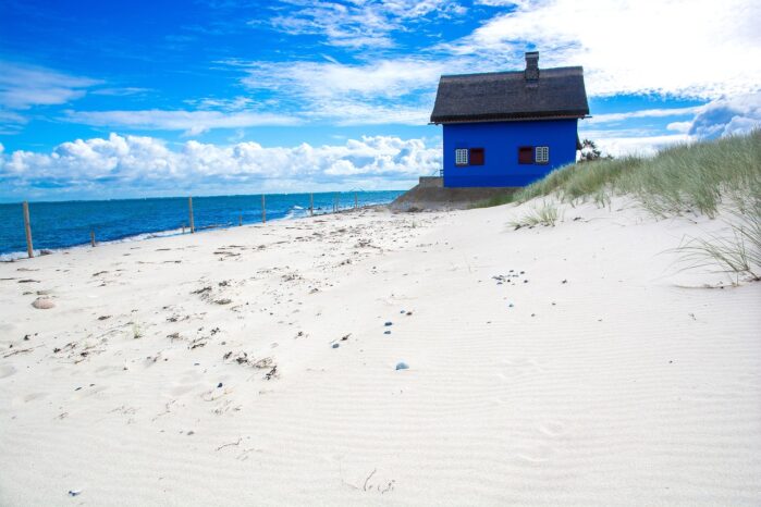 Heiligenhafen Strand mit blauem Haus zwischen Dünen und Ostsee